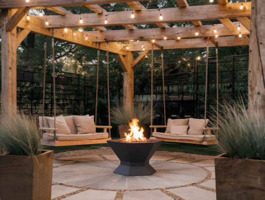Hexagonal black steel fire pit burning wood on a stone patio under a wooden pergola with swing seats and festoon lights outdoor garden fire pit Pyrova