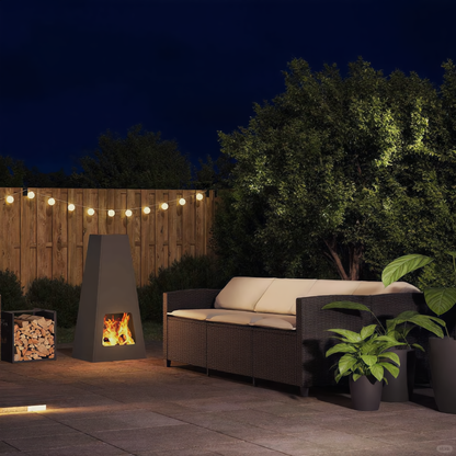 Anthracite steel pyramid chiminea fire pit burning wood on evening garden patio next to rattan sofa and string lights outdoor fire pit Pyrova

